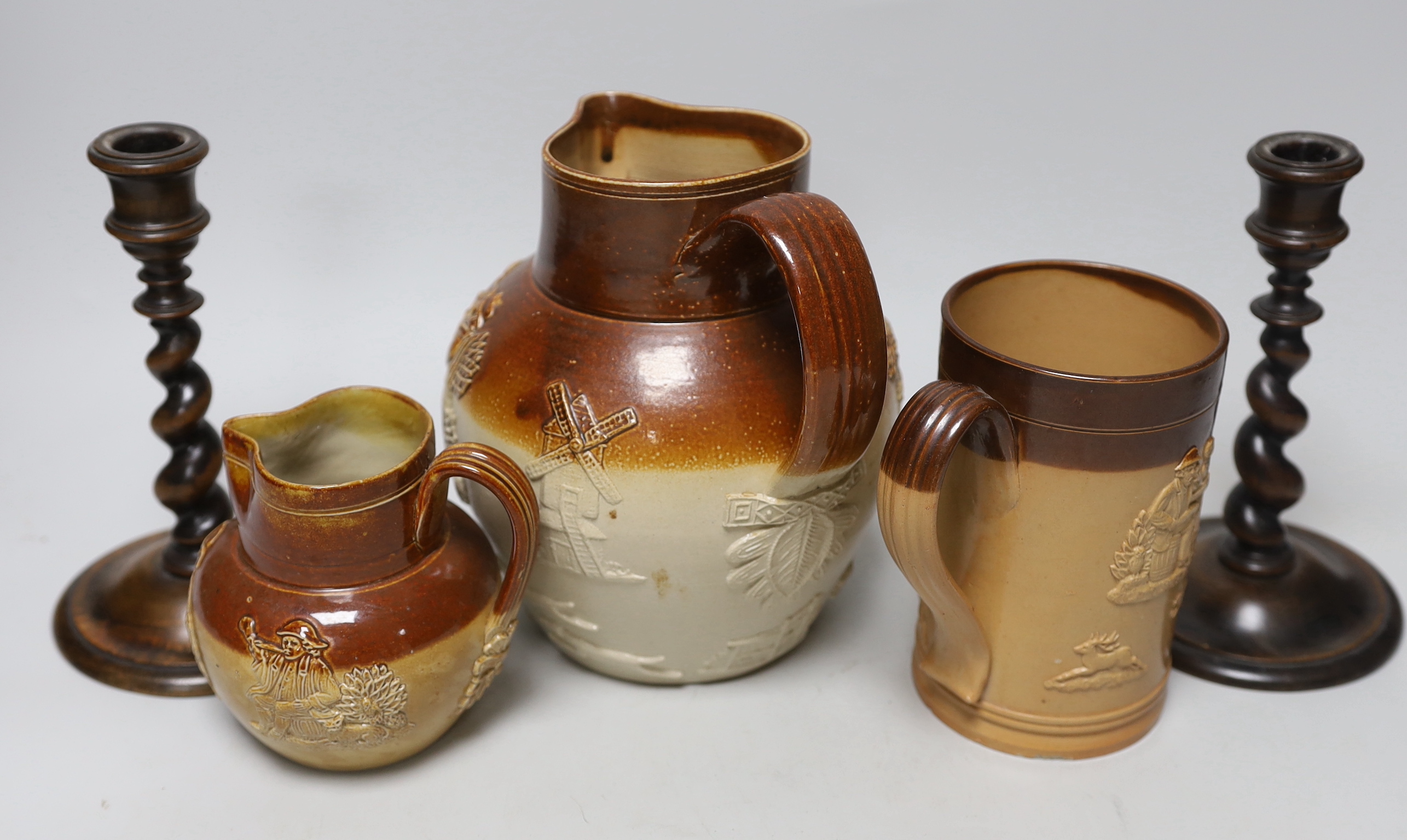 A group of three salt-glazed stoneware vessels and a pair of walnut barley-twist candlesticks, the largest 19cm high